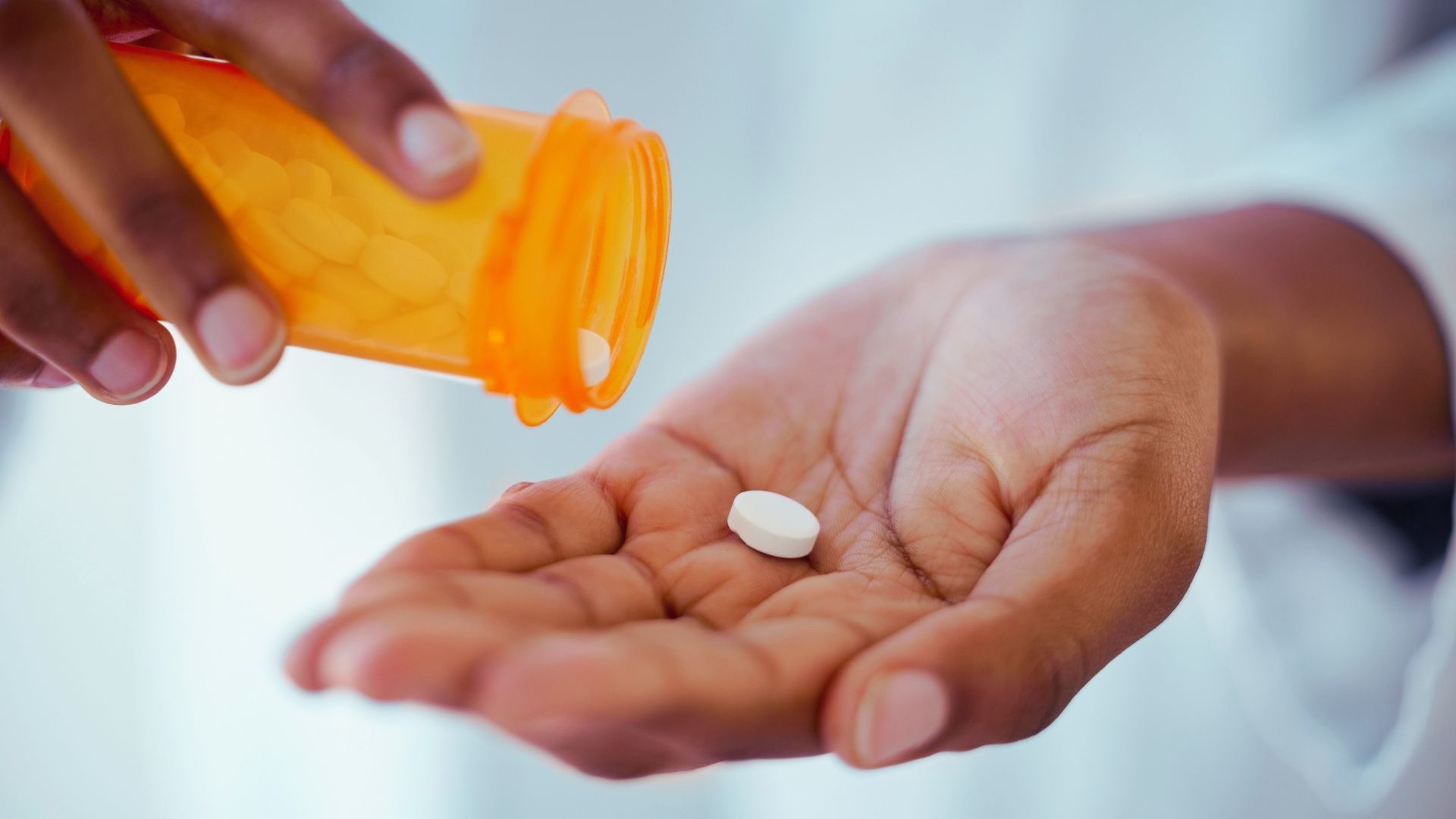 woman holding medication pill in her hand