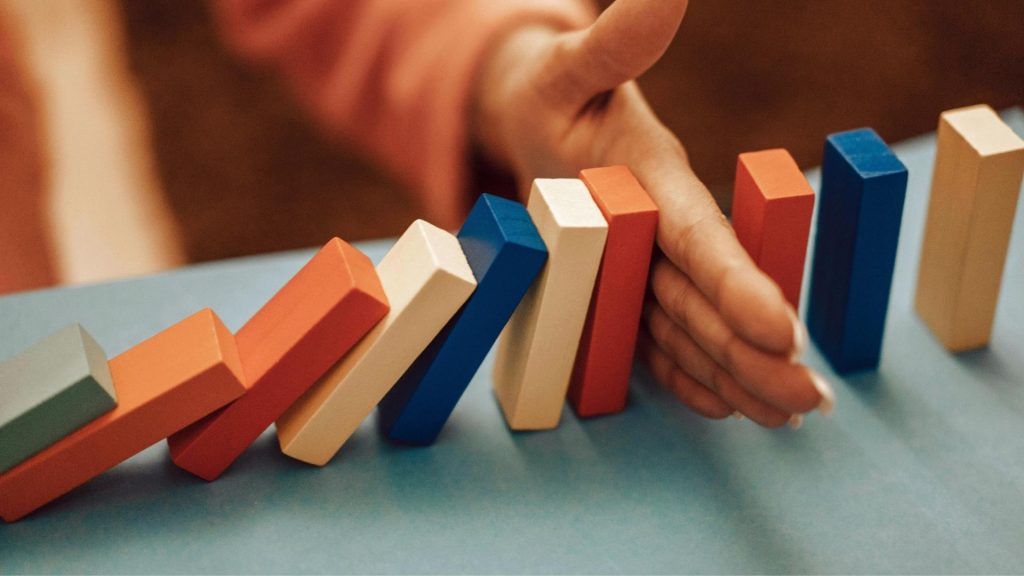 Person stopping a domino effect representing how Vivitrol interrupts addiction cycles.