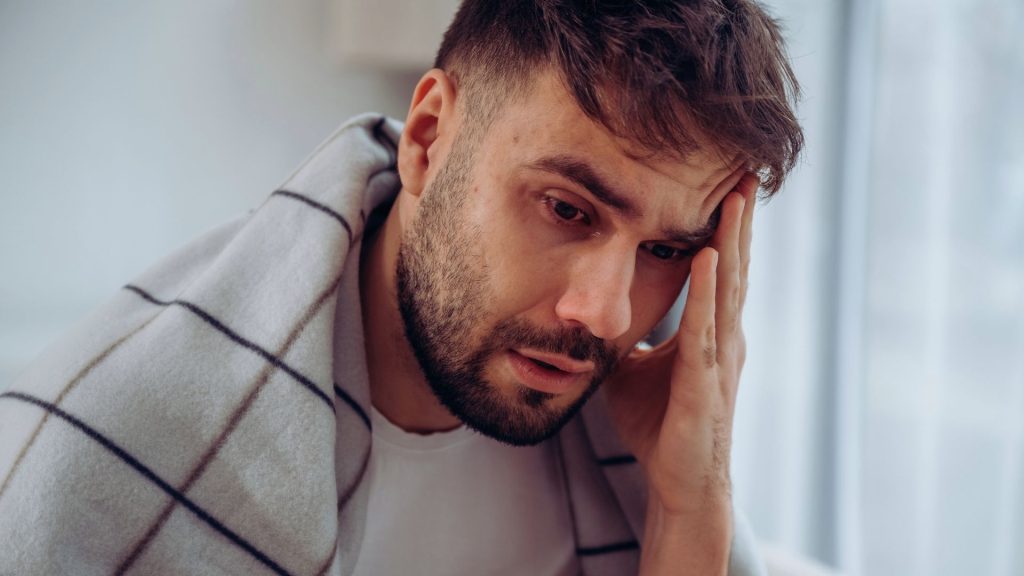 Person showing visible stress and emotional strain linked to addiction