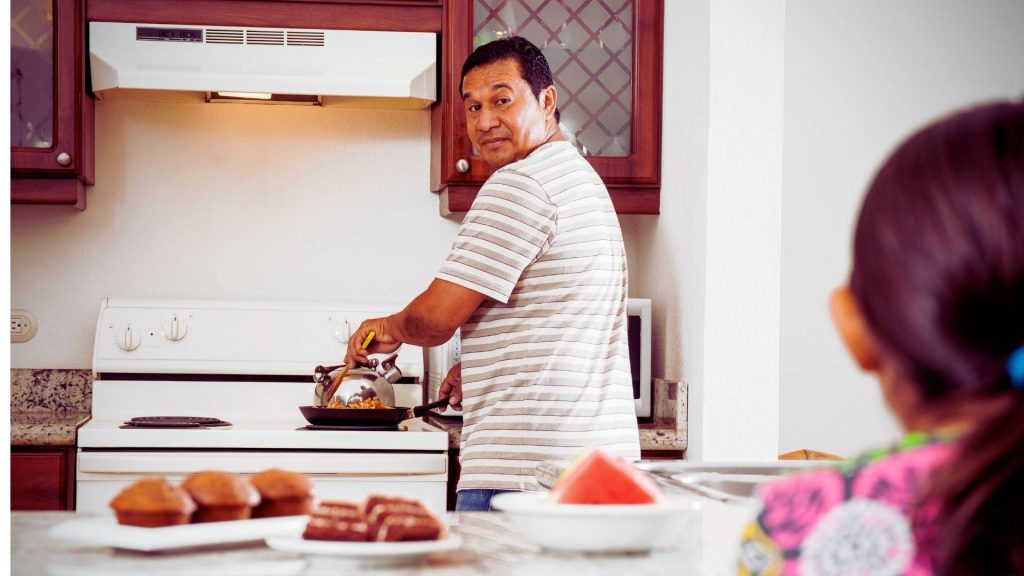 Man preparing a meal at home while managing daily responsibilities during IOP addiction treatment