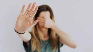 Childhood Trauma in Adults hero image of a woman covering her face.
