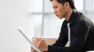 Panic Attack vs. Anxiety Attack hero image of a man examining the difference on a checklist.